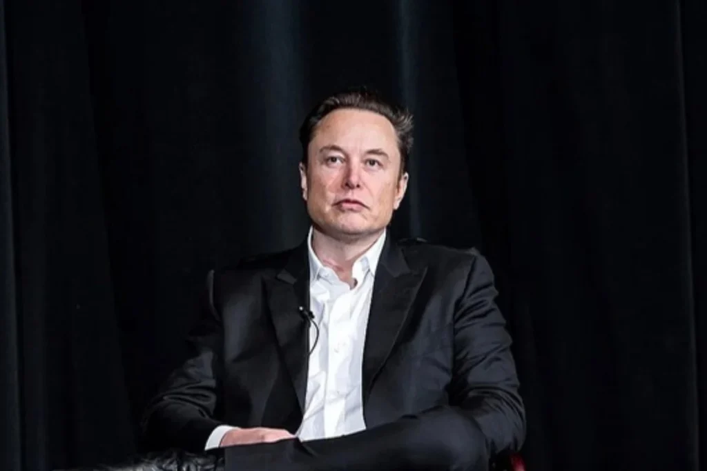 Elon Musk seated on stage looking serious, in a story about his split with Shivon Zilis