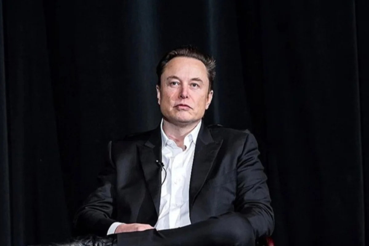 Elon Musk seated on stage looking serious, in a story about his split with Shivon Zilis